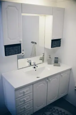 a white bathroom with a sink and a mirror at Dalhus - House with jacuzzi in Norddal