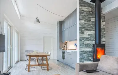 a living room with a table and a fireplace at Nice Home In Ornes With House Sea View in Ornes