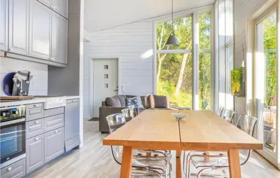 a kitchen and living room with a wooden table at Nice Home In Ornes With House Sea View in Ornes