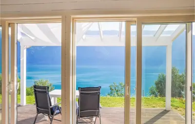 a room with sliding glass doors with a table and chairs at Nice Home In Ornes With House Sea View in Ornes