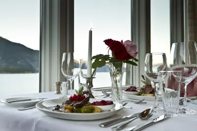 a table with plates of food and wine glasses at Kviknes Hotel in Balestrand