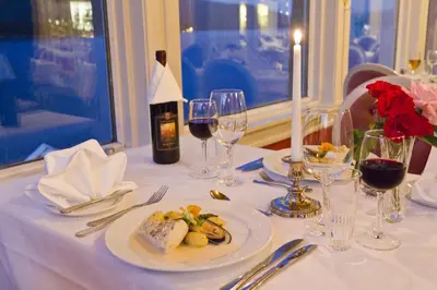 a table with a plate of food and wine glasses at Kviknes Hotel in Balestrand