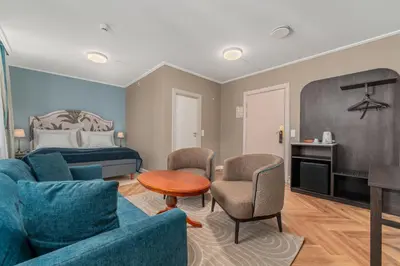 a living room with a couch and chairs and a bed at Hotel Breiseth in Lillehammer