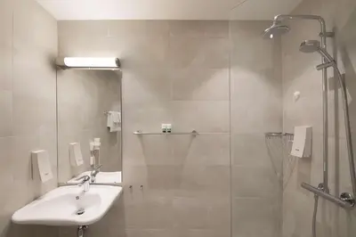a bathroom with a sink and a shower at Bergen Harbour Hotel, WorldHotels Crafted in Bergen