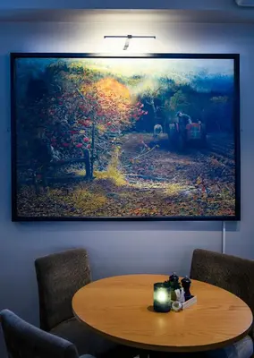 a painting hanging on a wall with a wooden table at Home Hotel Hammer in Lillehammer