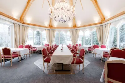 a dining room with tables and chairs and a chandelier at Scandic Valdres in Fagernes