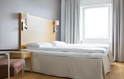a large bed in a room with a window at Comfort Hotel Fosna in Kristiansund
