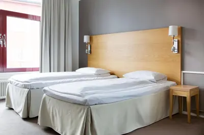 two beds in a hotel room with a window at Comfort Hotel Fosna in Kristiansund