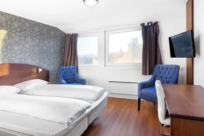 a hotel room with two beds and a desk at Comfort Hotel Fosna in Kristiansund
