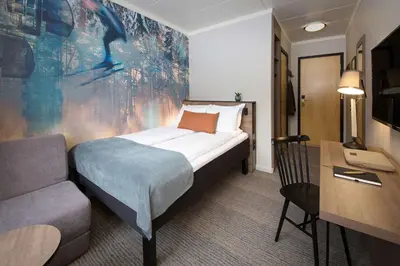 a hotel room with a bed and a couch and a desk at Scandic Hafjell in Hafjell