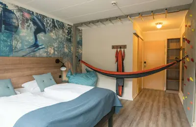 a bedroom with a bed and a hammock on the wall at Scandic Hafjell in Hafjell