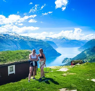 two women standing on a mountain with a view of a lake at Valldal Fjord Lodge B&B in Valldal