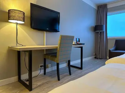 a room with a desk with a television and a chair at Beito Resort Hotel in Beitostøl