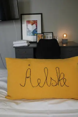 a yellow pillow with the word mail on a bed at Stasjonen Hotel in Lillehammer