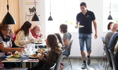 a group of people sitting around a table eating food at Stasjonen Hotel in Lillehammer