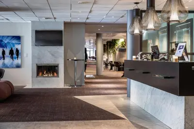 an office lobby with a fireplace in the middle at Quality Airport Hotel Værnes in Stjoerdal