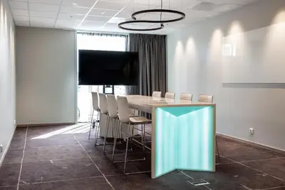 a conference room with a table and chairs and a flat screen tv at Quality Airport Hotel Værnes in Stjoerdal