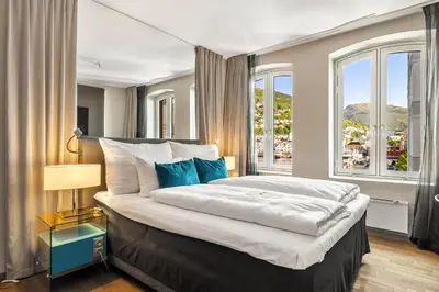 a bedroom with a large bed with a large window at Clarion Hotel Admiral in Bergen