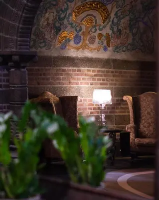 a room with two chairs and a lamp on a brick wall at Home Hotel Havnekontoret in Bergen