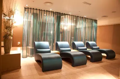 a row of blue chairs in a waiting room at Home Hotel Havnekontoret in Bergen