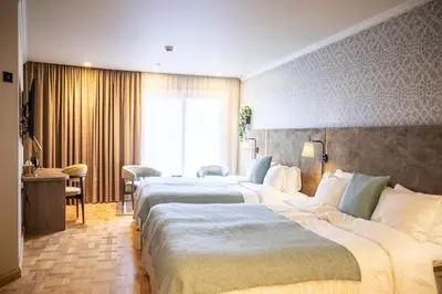 a hotel room with two beds and a table at Home Hotel Havnekontoret in Bergen