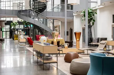 a lobby with chairs and tables in a building at Quality Hotel Edvard Grieg in Bergen