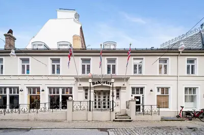 a large white building with flags in front of it at Best Western Plus Hotel Bakeriet in Trondheim