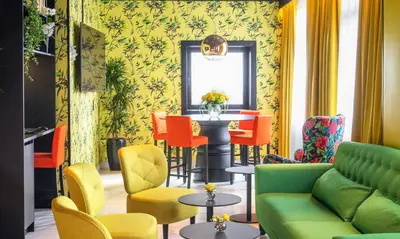 a living room with a green couch and colorful chairs at Thon Hotel Moldefjord in Molde