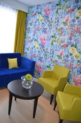 a living room with a blue couch and two yellow chairs at Thon Hotel Moldefjord in Molde