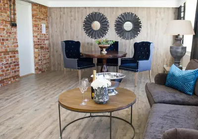 a living room with a table and chairs and mirrors at Klækken Hotel in Hønefoss