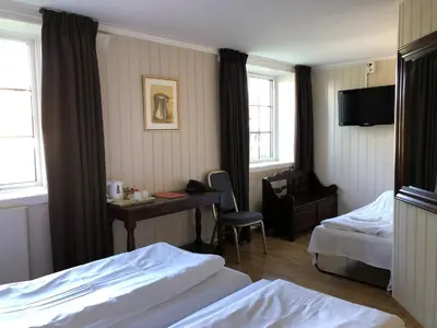 a hotel room with two beds and a desk with a computer at Klækken Hotel in Hønefoss
