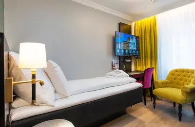 a room with a bed and a tv and a chair at Thon Hotel Rosenkrantz Bergen in Bergen
