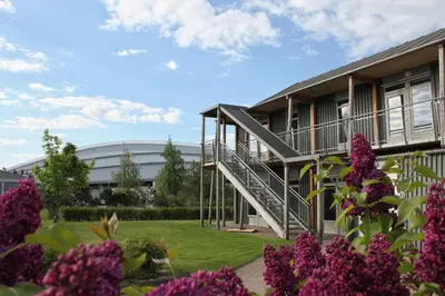 a building with purple flowers in front of it at Vikingskipet Hotell in Hamar