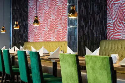 a dining room with wooden tables and green chairs at Thon Hotel Orion in Bergen