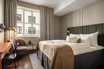 a hotel room with a bed and a desk at Home Hotel Bryggen in Bergen