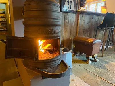 a stove with a fire in a room at Herangtunet Mountain Lodge in Heggenes