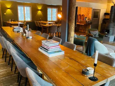 a long wooden table with books on top of it at Herangtunet Mountain Lodge in Heggenes