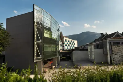 a glass building with a mountain in the background at Quality Hotel Sogndal in Sogndal