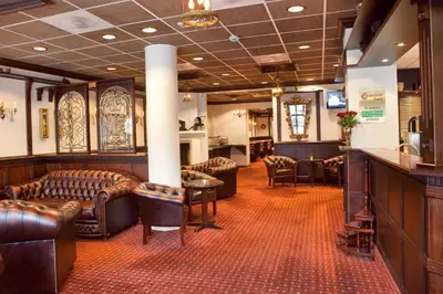 a bar with couches and chairs in a room at Chesterfield Hotel in Trondheim