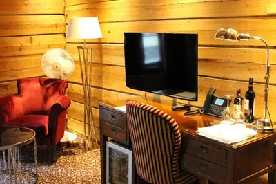 a room with a desk with a television and a chair at Det Hanseatiske Hotel in Bergen