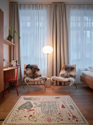 a living room with two chairs and a rug at Hotel 1904 in Ålesund