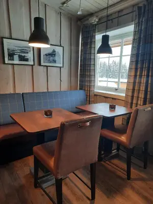 a dining room with two tables and two chairs at Hafjell Hotell in Hafjell