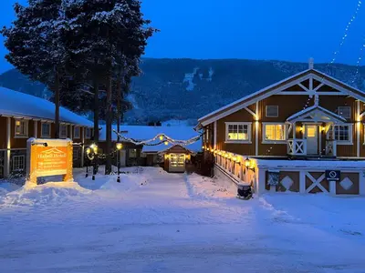 a building with lights in the snow at night at Hafjell Hotell in Hafjell