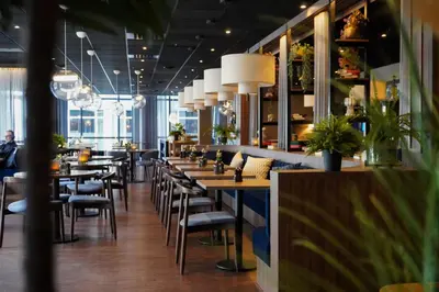 a row of tables and chairs in a restaurant at Home Hotel Grand Olav in Trondheim