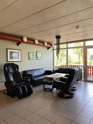 a waiting room with leather chairs and a table at Trædal Hotel in Sunndalsøra
