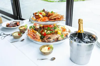 a table topped with plates of food and a bottle of champagne at Gudvangen Fjordtell in Gudvangen