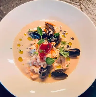 a white plate with a dish of food on a table at Gudvangen Fjordtell in Gudvangen