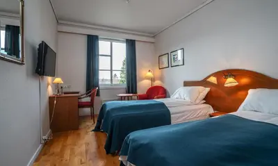 a hotel room with two beds and a television at Thon Hotel Selbusjøen in Selbu