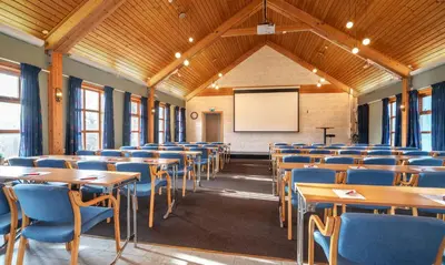 an empty classroom with tables and chairs and a whiteboard at Thon Hotel Selbusjøen in Selbu