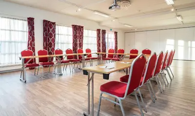 a conference room with red chairs and a table at Thon Hotel Selbusjøen in Selbu